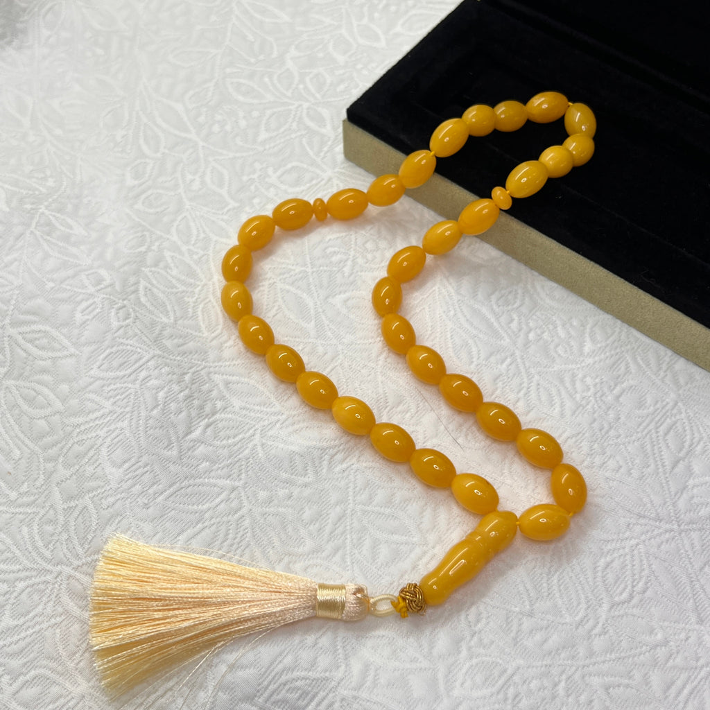 Golden amber-tone Tasbih with polished oval beads and cream tassel