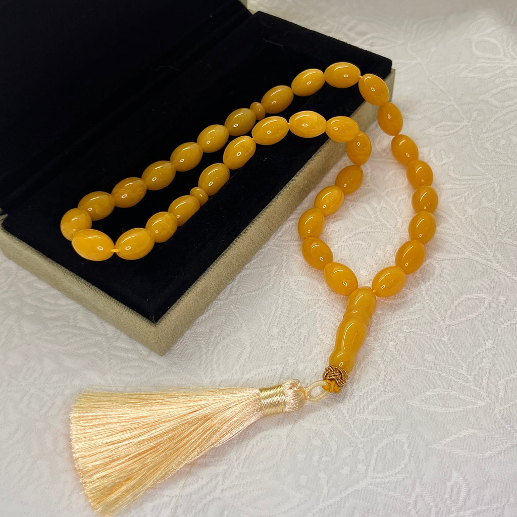 Golden amber-tone 33-bead Tasbih displayed with cream tassel
