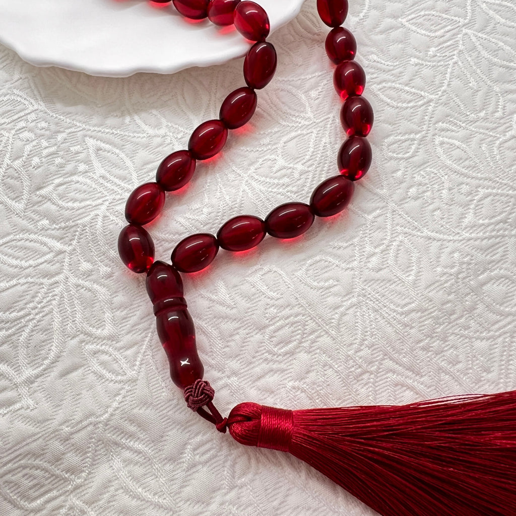 Close view of translucent-look ruby red Tasbih beads and tassel