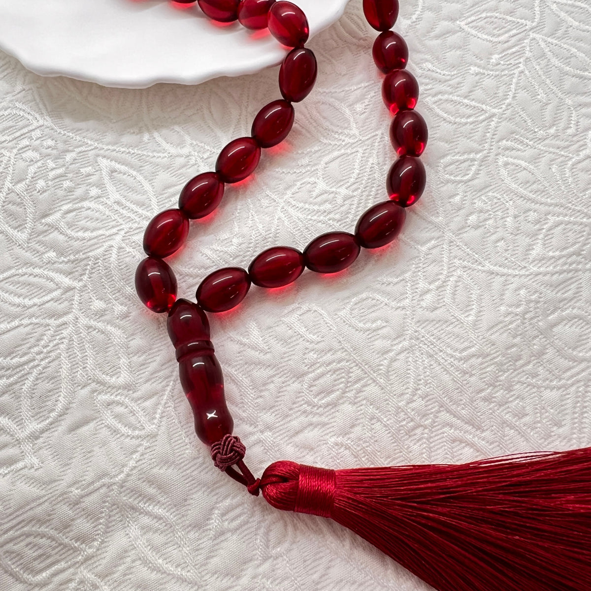 Close view of translucent-look ruby red Tasbih beads and tassel