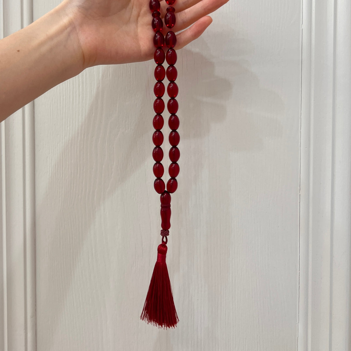 Ruby Red 33-bead Tasbih shown in hand for scale