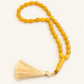 golden 33-bead resin tasbih on cream background